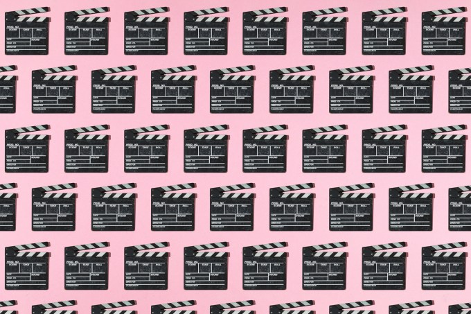 Wooden old movie clapperboard pattern with hard shadow on pink background. Concept of film industry, cinema, entertainment, and Hollywood.