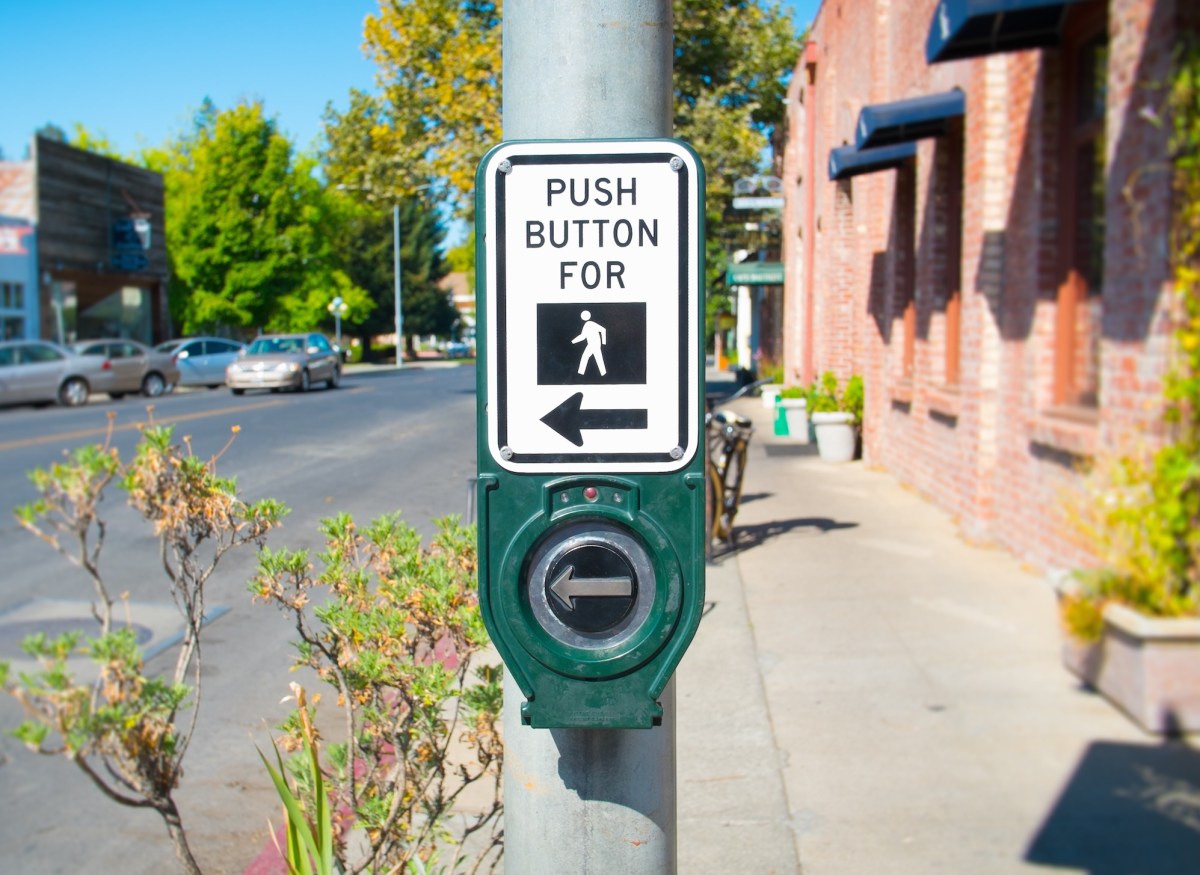 a photo of a crosswalk button that reads, 