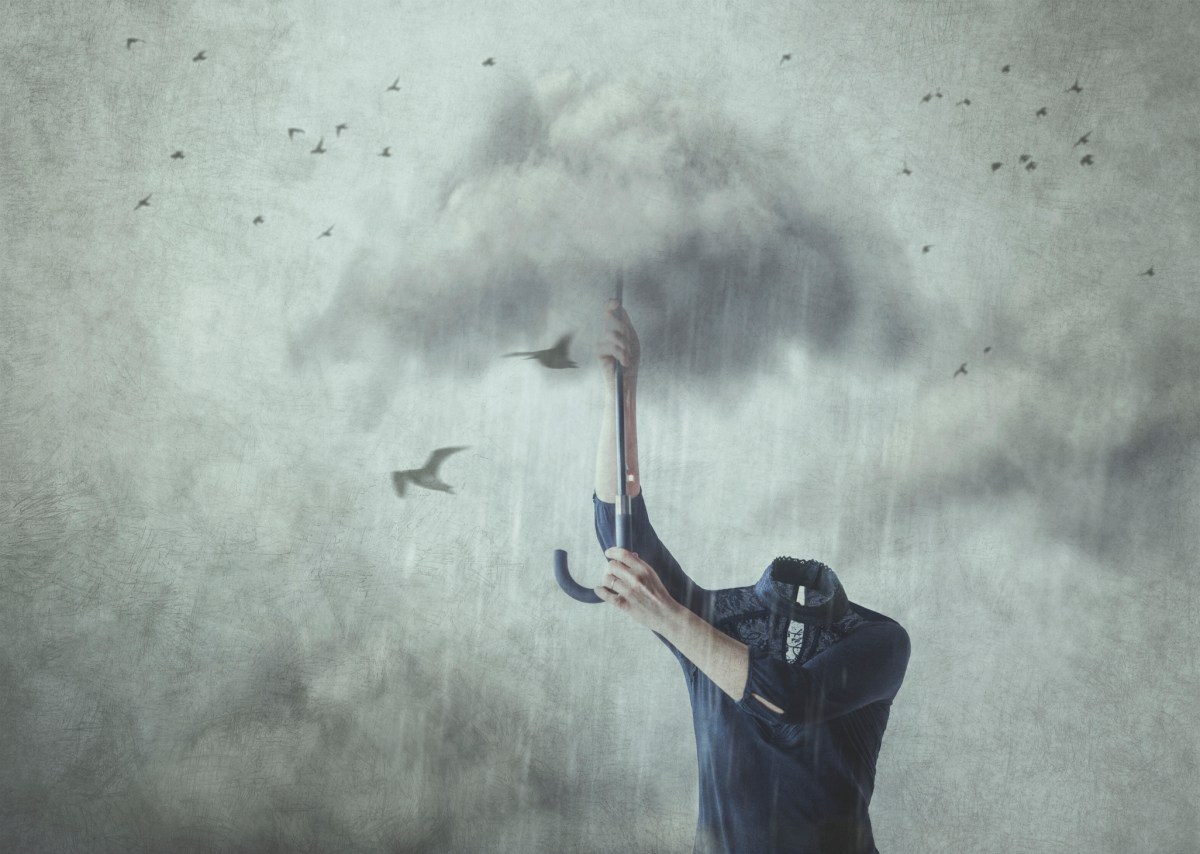 Concept of losing your mind; headless man holding up umbrella made of clouds