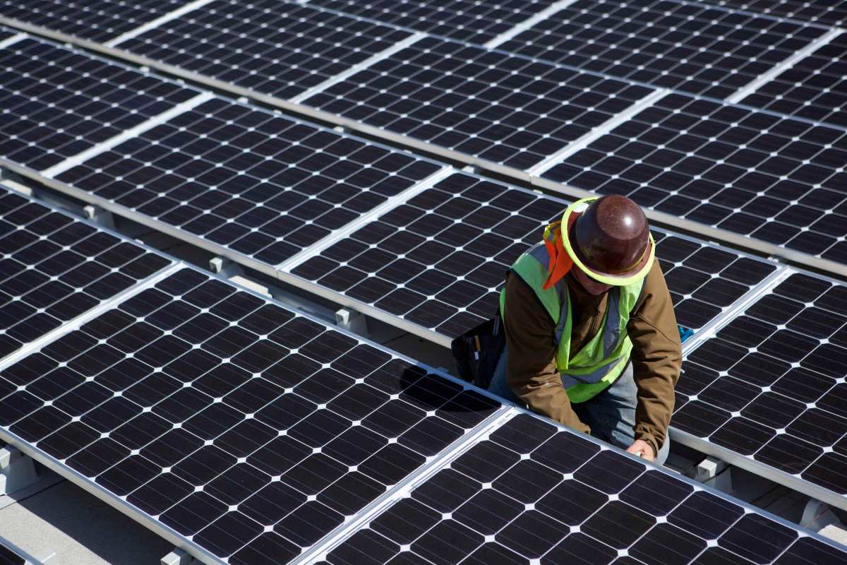 A man inspects solar panels.