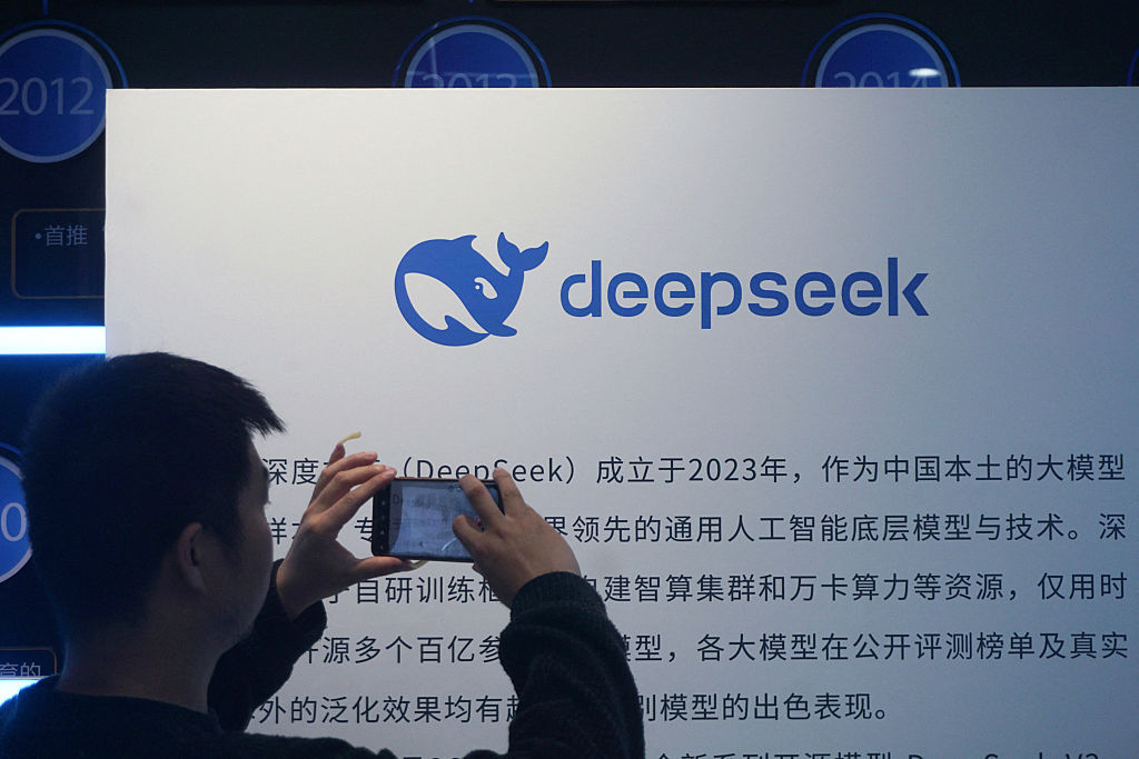 A man takes photos of a DeepSeek display at a shopping mall in Hangzhou