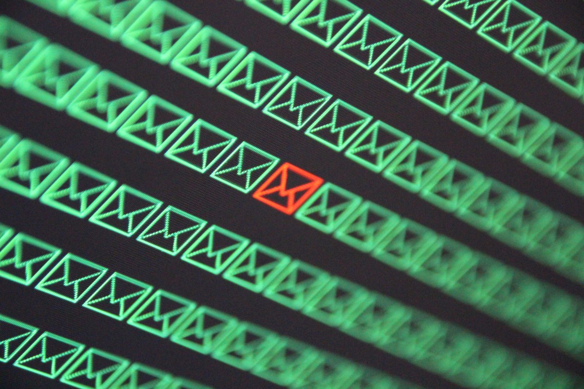 red email envelope in a sea of green email envelopes